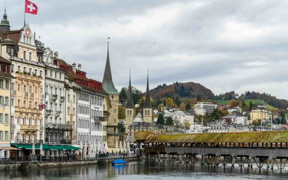 Lucerne, ville suisse au charme intact : pont de bois, drapeaux rouges et ambiance de vacances entre lac et montagnes.