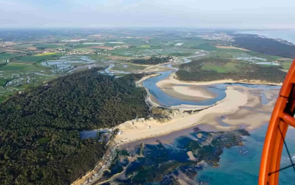 Vue aérienne de la plage du Veillon avec bancs de sable, estuaire sinueux et végétation côtière, paysage typique du littoral vendéen.
