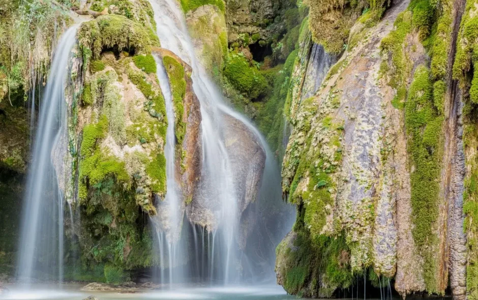 Eau claire s’écoulant en nappes sur des roches moussues, image d’une visite apaisante à la cascade des Tufs.