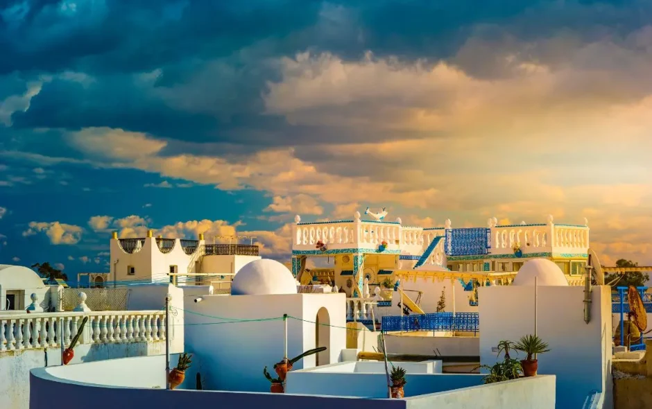 Architecture blanche et bleue au coucher du soleil, image évoquant l’atmosphère méditerranéenne de Hammamet