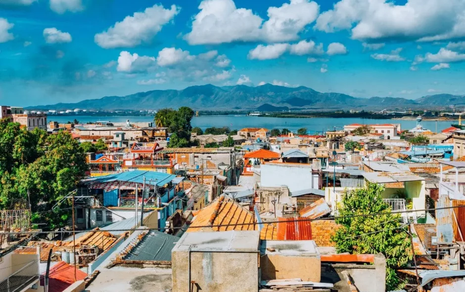 Vue colorée sur les toits de Santiago de Cuba avec montagnes verdoyantes et ciel bleu en arrière-plan