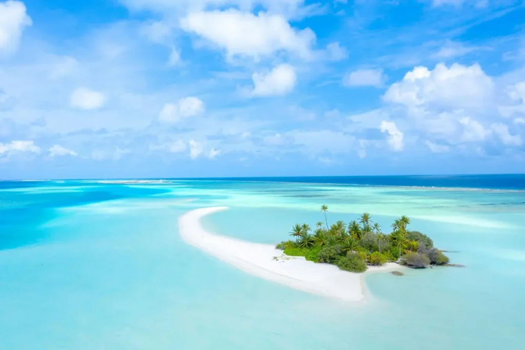 Petite île tropicale entourée d’eaux turquoise cristallines illustrant le cadre paradisiaque idéal pour pratiquer le snorkeling aux Maldives.