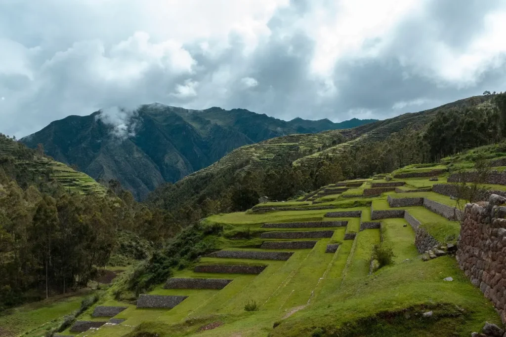 Terrasses incas en pierre dans les Andes péruviennes entourées de forêts et montagnes, image d’une ingénierie ancestrale adaptée au relief montagneux.