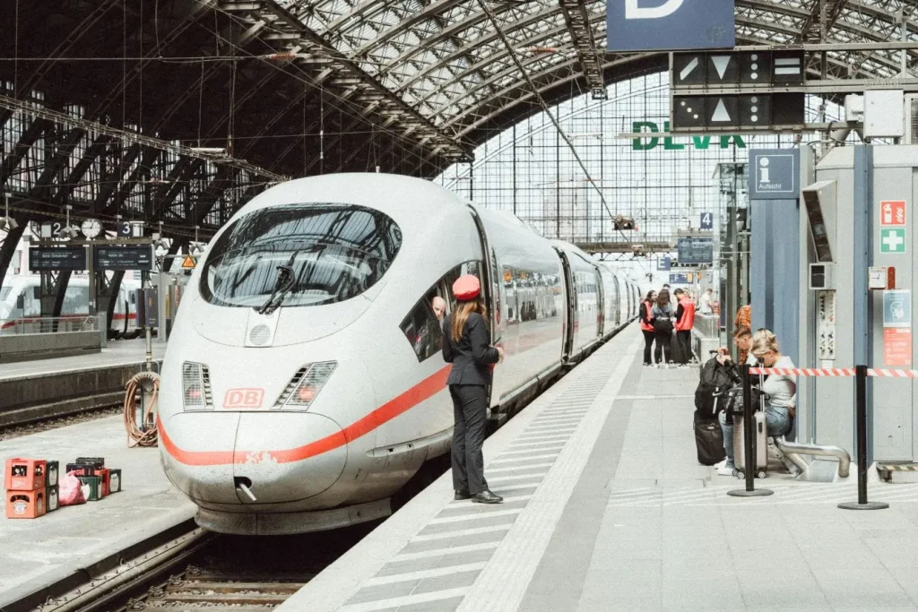 Train moderne en gare avec passagers et personnel, image illustrant l’efficacité des transports ferroviaires pour se déplacer à Tokyo.