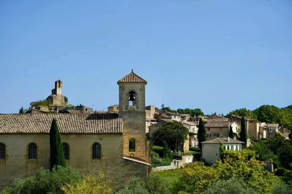 Village provençal avec clochers et maisons en pierre aux toits de tuiles, image illustrant le charme authentique et historique des villages de Provence.