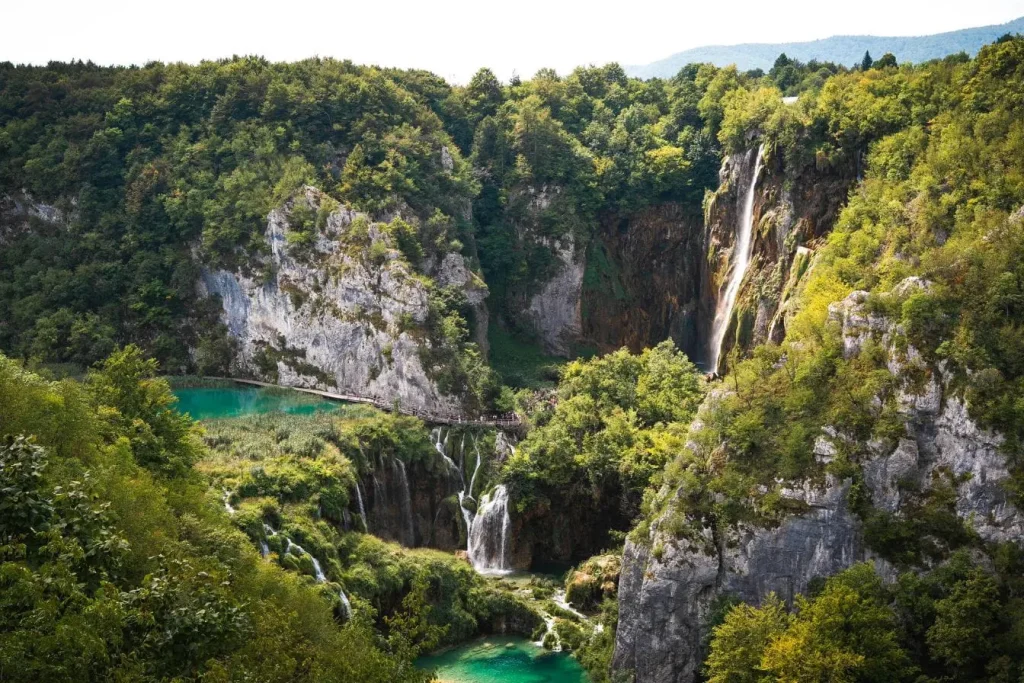 Cascades majestueuses plongeant dans bassins turquoise entourés de forêt luxuriante illustrant la beauté des meilleurs parcs nationaux des USA