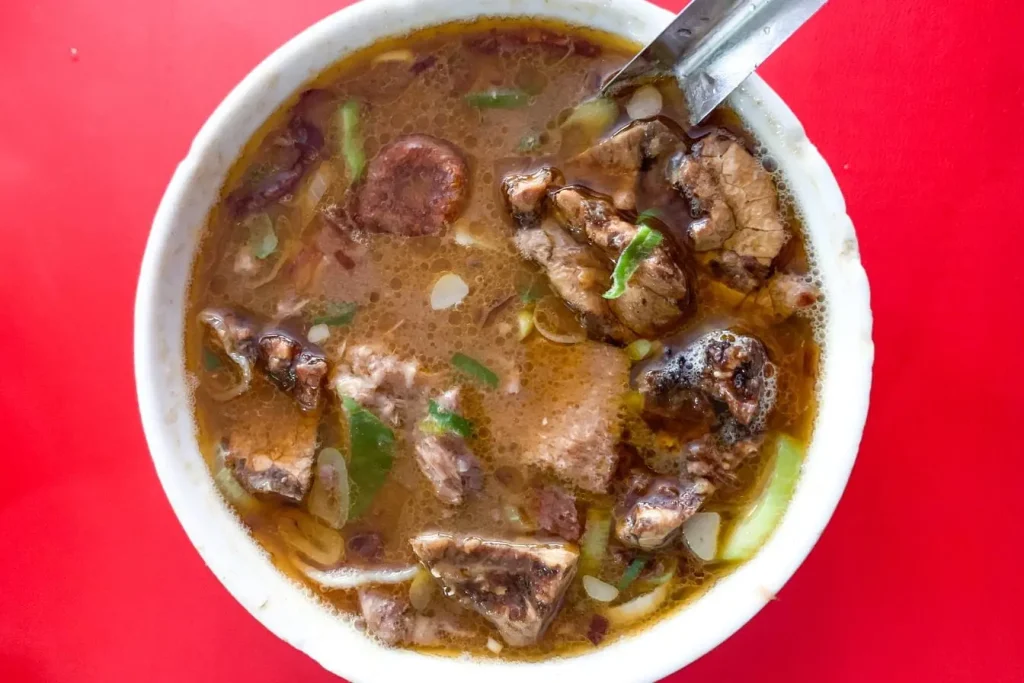 Plat de soupe chaude avec viande et légumes servi dans un bol illustrant une spécialité bretonne