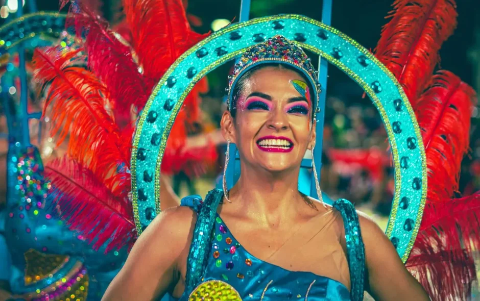 Artiste en tenue brillante ornée de gemmes et plumes, entouré de festivaliers, illustrant l’esprit vibrant du carnaval de Rio