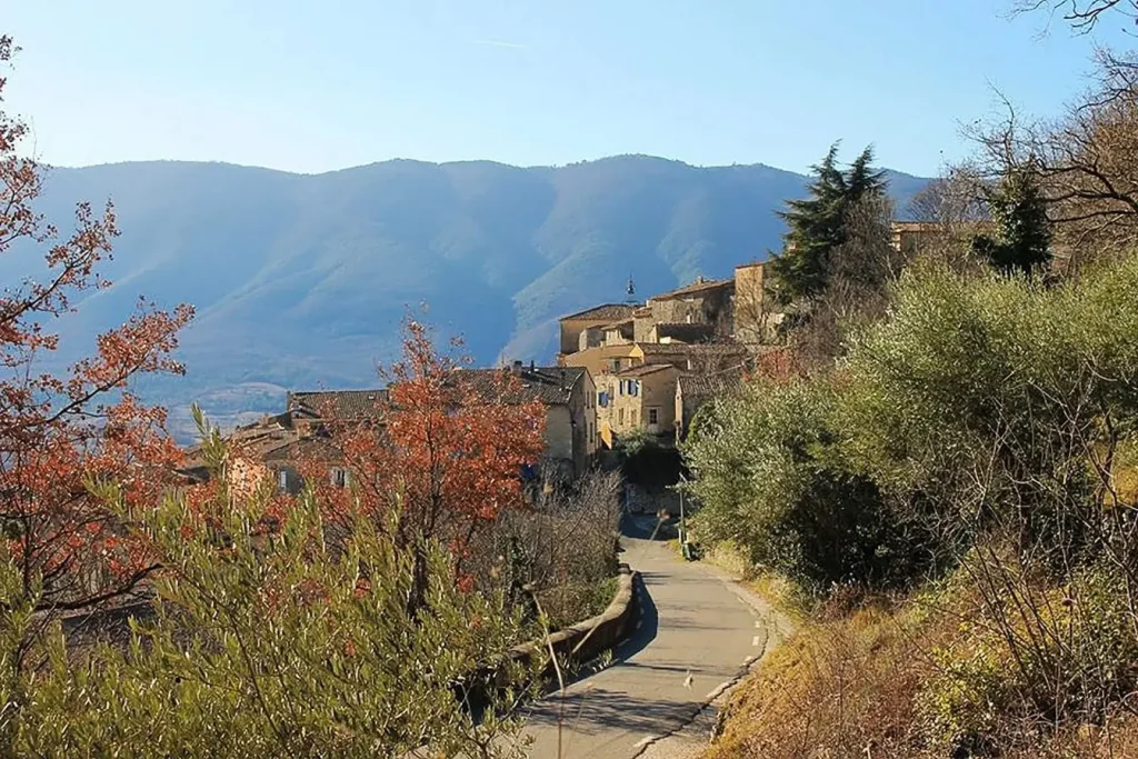 Village provençal niché sur une colline avec maisons en pierre et toits de tuiles, image illustrant le charme authentique et pittoresque de la Provence.