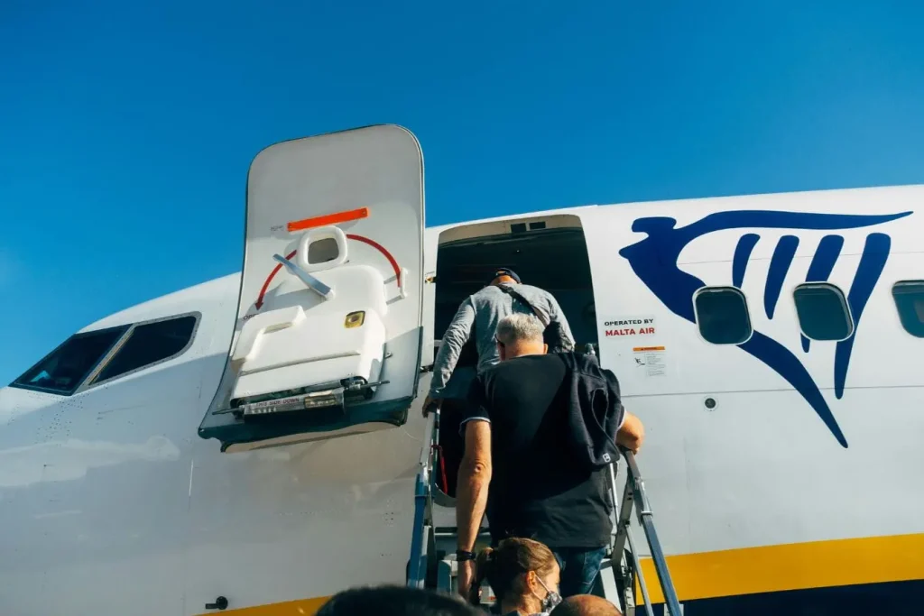 Voyageurs embarquant sur avion blanc et bleu, image représentant la recherche de vols pas chers et l’optimisation du budget.