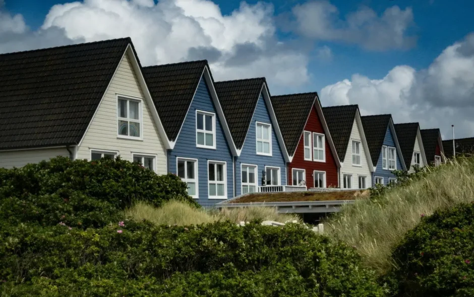 Rangée de maisons colorées avec toits pentus, image évoquant la recherche d’un logement chez l’habitant dans un cadre convivial et harmonieux.