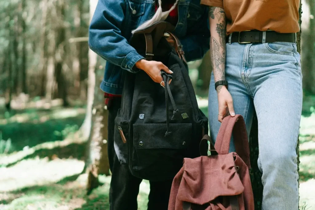 Deux personnes en forêt portant sacs à dos, image illustrant le sac à dos de voyage et l’esprit d’aventure en pleine nature.