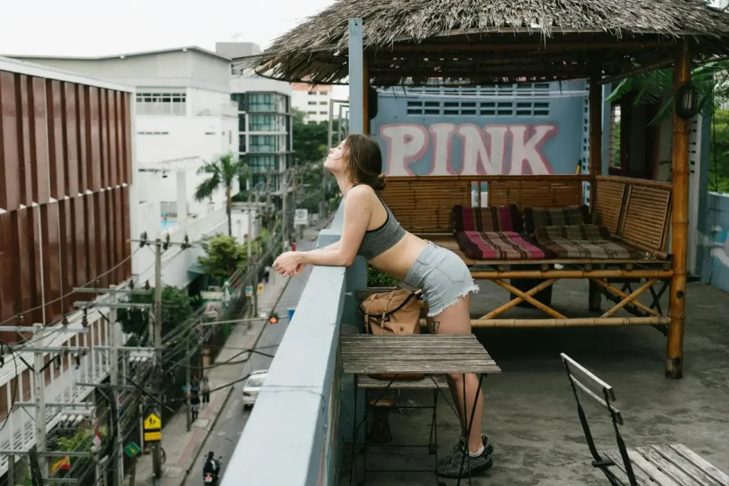 Personne appuyée sur une rambarde observant la ville, image évoquant un voyage avec un très petit budget en profitant de moments simples et accessibles.