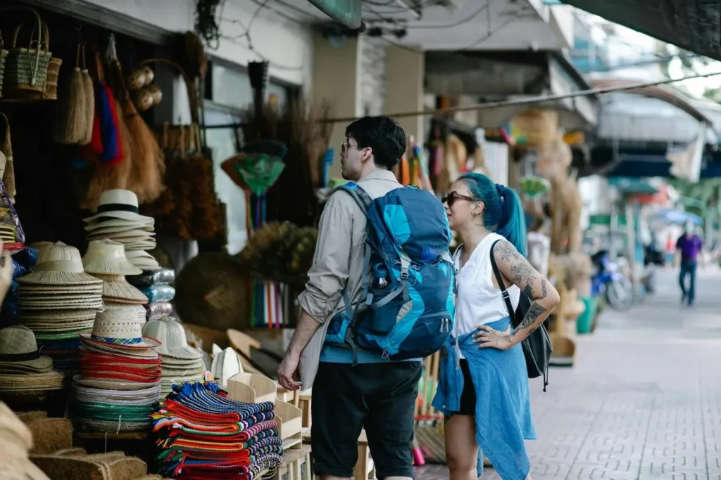 Deux voyageurs devant étal de marché coloré