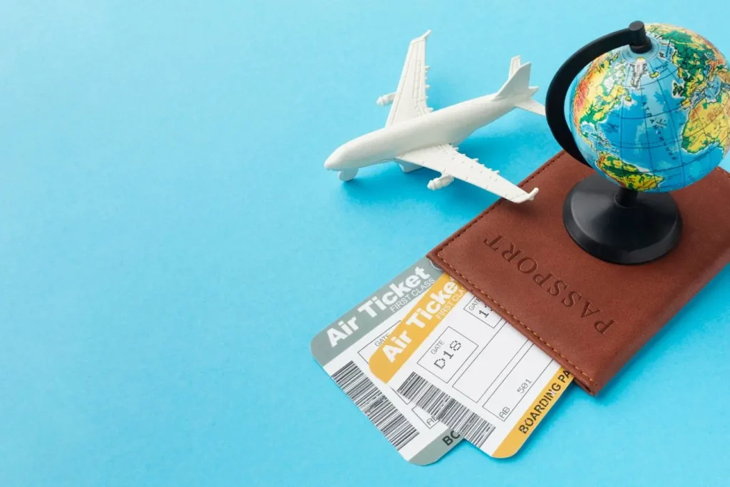 Globe miniature, avion blanc et passeport avec billets, image évoquant le risque de vol de documents et les démarches urgentes pour rentrer.