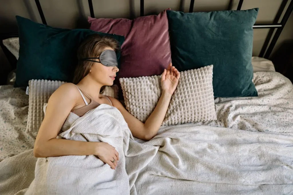 Personne allongée au calme avec masque de sommeil, image illustrant l’importance du repos pour éviter le mal des transports en avion.