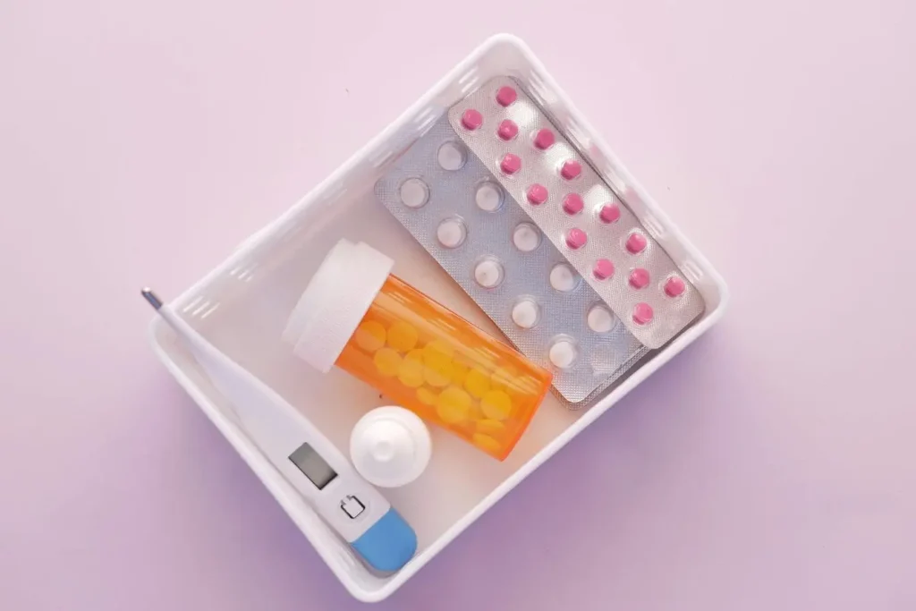 Ensemble de médicaments et accessoires médicaux dans plateau, représentant la trousse à pharmacie de voyage pour prévenir les imprévus.