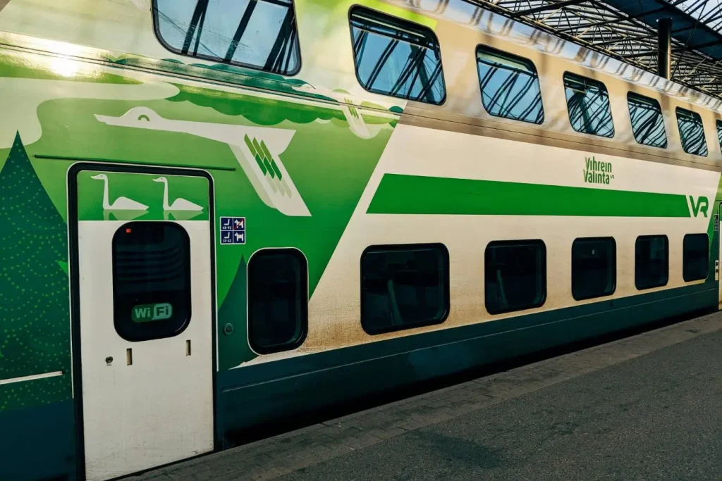 Train écologique à deux étages stationné sous verrière, image d’un transport responsable qui réduit l’empreinte carbone des voyageurs.