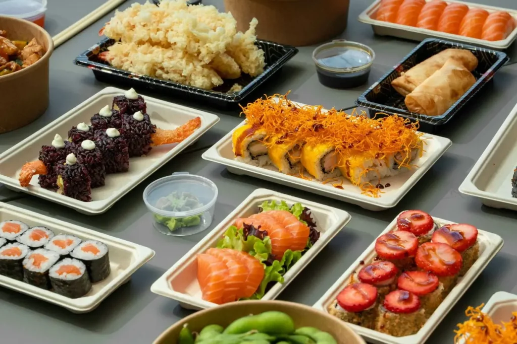 Table garnie de sushis colorés et plats variés, image qui illustre la richesse culinaire que l’on découvre en visitant l’Azerbaïdjan.