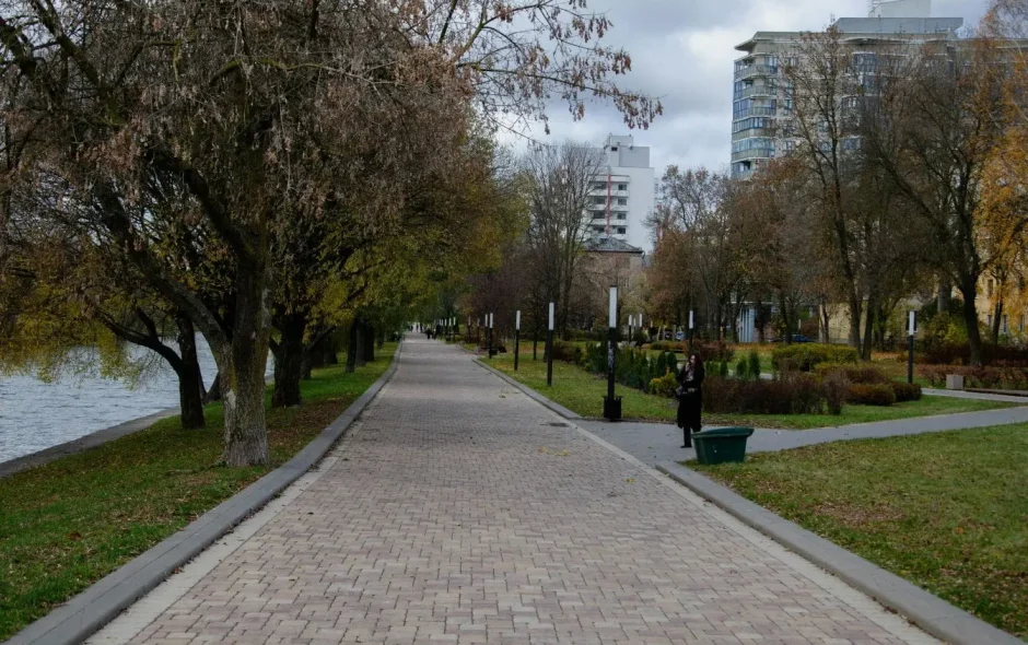 Promenade sur une allée pavée bordée d’arbres et lampadaires, image qui illustre une balade incontournable à Minsk.