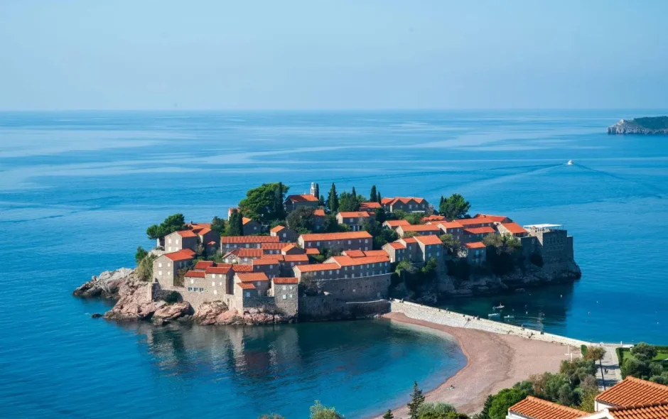 Vue aérienne d’une île reliée au continent par chaussée étroite, image illustrant un paysage méditerranéen proche de Podgorica.