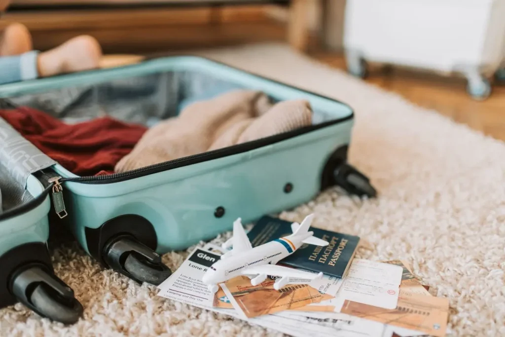 Passeport et billets posés près d’une valise, symbole d’une organisation efficace pour limiter les frais de bagages.
