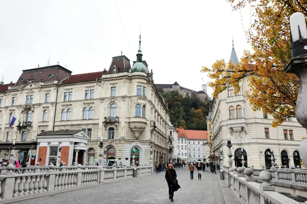 Vue sur pont de pierre animé et façades historiques, image qui illustre la découverte de Ljubljana lors d’un séjour de cinq jours en Slovénie.