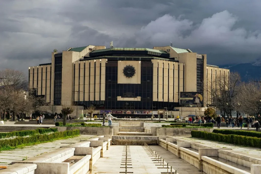 Vue sur le Palais national de la culture avec façade géométrique et grande esplanade, image qui illustre l’idée de visiter Sofia Bulgarie.