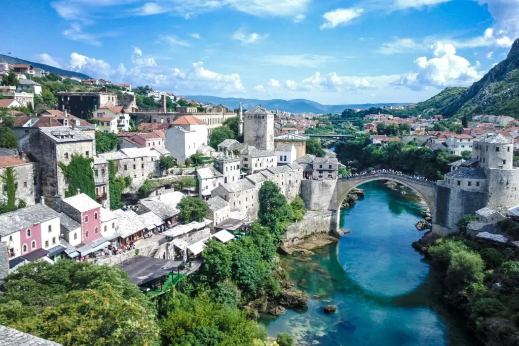 Vue pittoresque de Mostar avec pont ancien et toits rouges, reflet d’un circuit en Bosnie-Herzégovine.