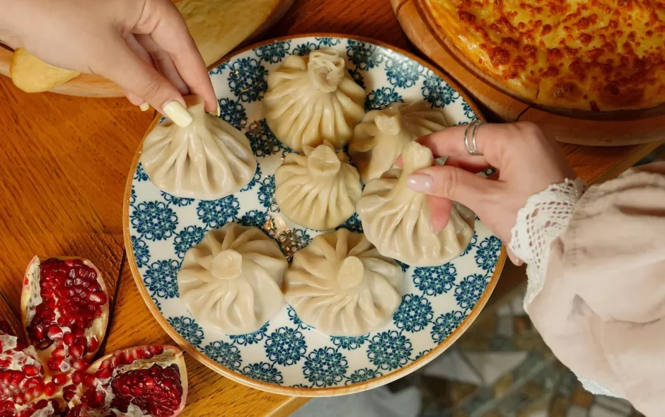 Khinkali traditionnels posés sur assiette bleue et blanche, illustration des spécialités culinaires géorgiennes.