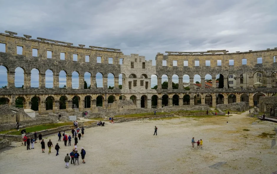 Vue intérieure de l’amphithéâtre romain de Pula avec arches en pierre, reflet d’un site incontournable à visiter en Croatie.